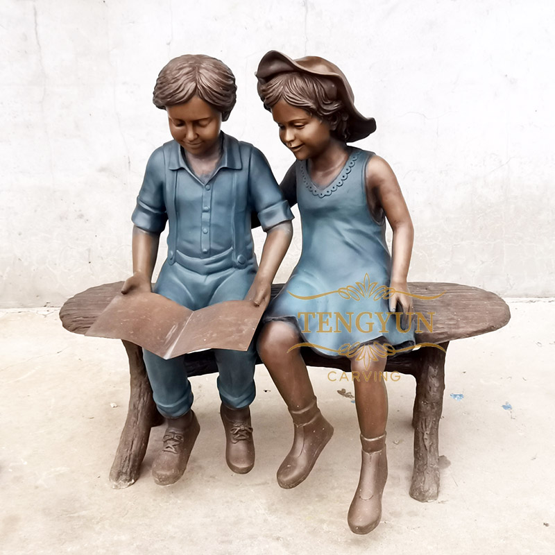 Boy and girl statue sitting on bench reading sculpture (3)