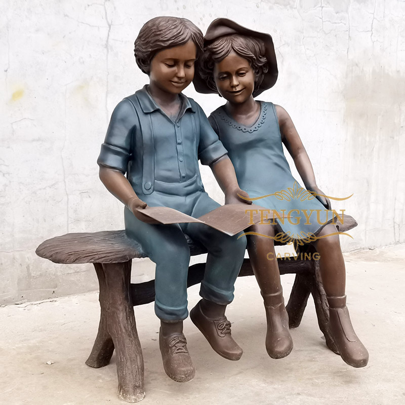 Boy and girl statue sitting on bench reading sculpture (4)